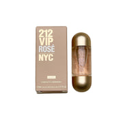 A mini bottle of 212 VIP ROSE ELYXIR by Carolina Herrera, placed next to its packaging box. The bottle is gold-colored with a clear cap, and the box has '212 VIP ROSE NYC' printed in gold lettering.