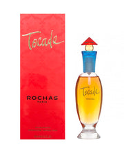A product image featuring TOCADE EAU DE TOILETTE SPRAY by ROCHAS. The image shows the perfume bottle with a red cap on a white background, accompanied by its red packaging box.