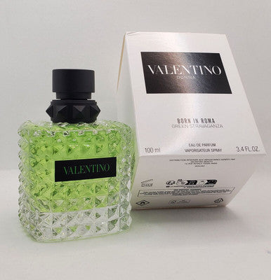 A VALENTINO DONNA BORN IN ROMA green eau de parfum spray bottle with a black cap next to its packaging box.