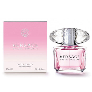 A product image showing a Versace Bright Crystal eau de toilette spray bottle next to its packaging box. The bottle is transparent with a pink liquid visible inside and features the Versace brand name.