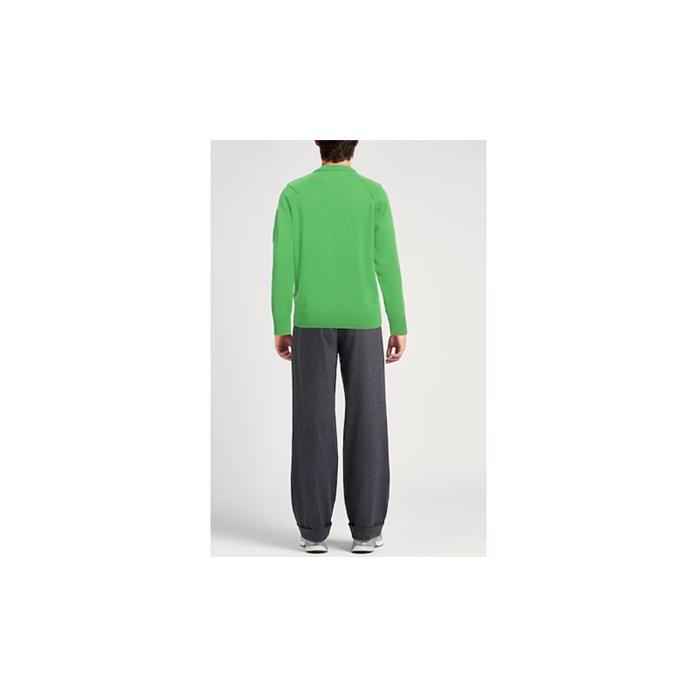 Person wearing a green sweater and gray pants next to C.P. Company white wool sweater