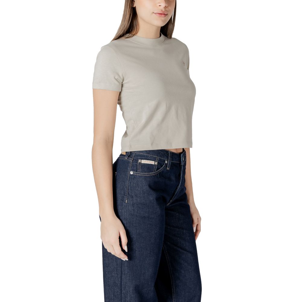 Woman wearing Calvin Klein Jeans beige cotton top and dark denim jeans outfit