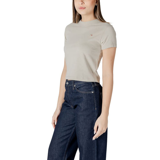 Woman styled in Calvin Klein Jeans beige cotton top and dark blue jeans