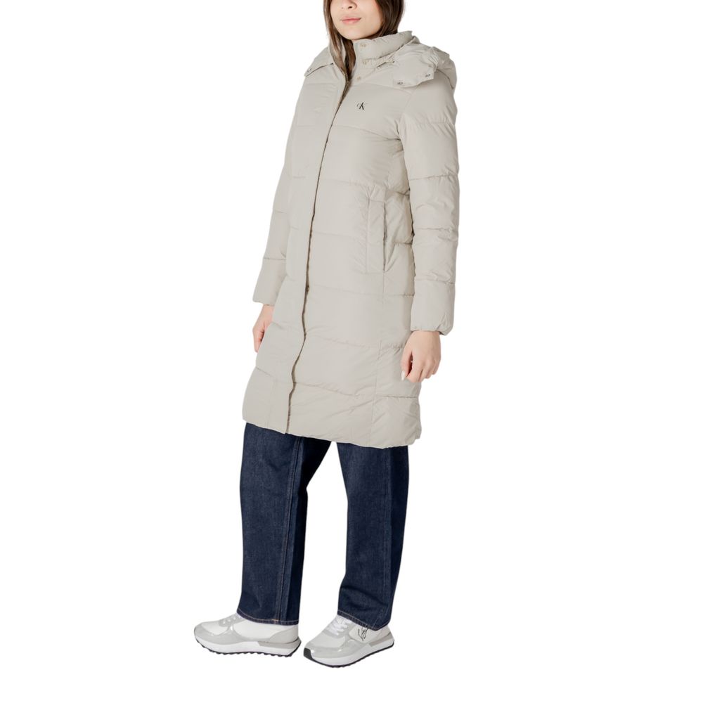 Woman wearing Calvin Klein Jeans beige polyester jacket and long puffer coat