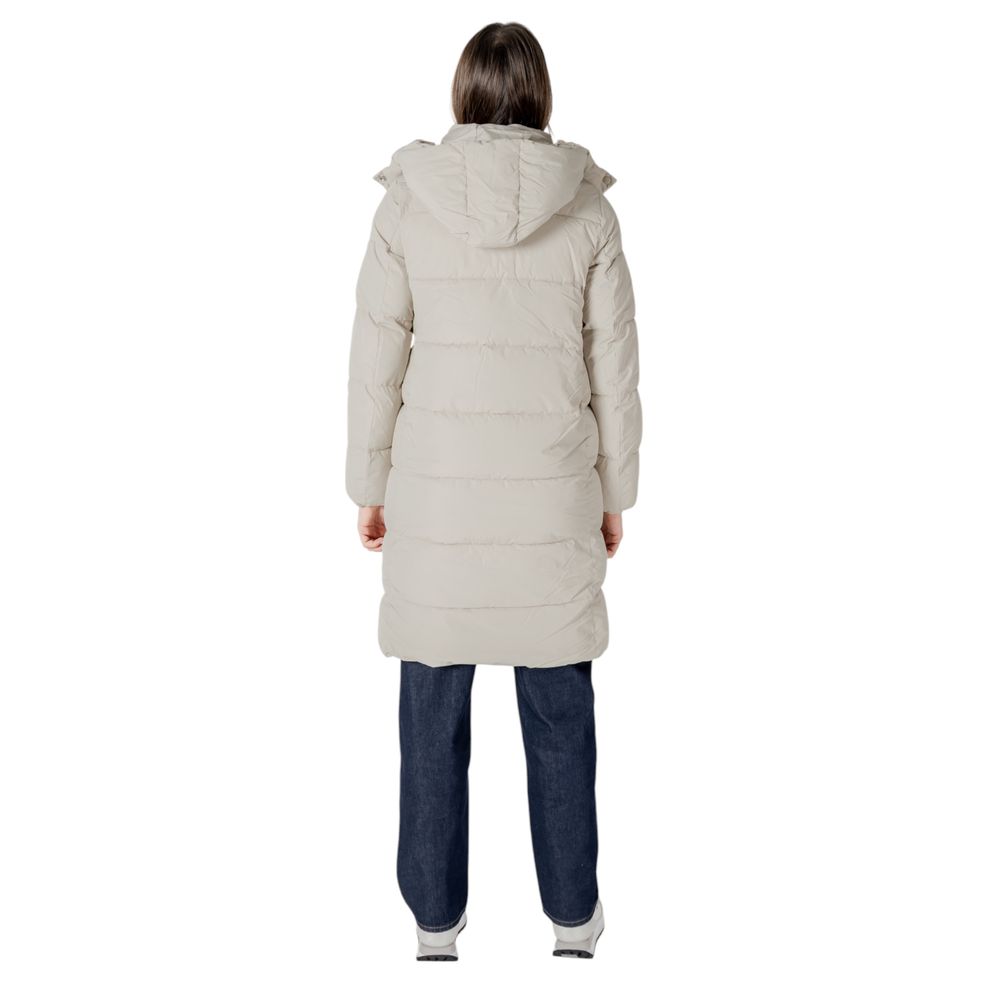 Woman wearing Calvin Klein Jeans beige polyester jacket and dark blue pants