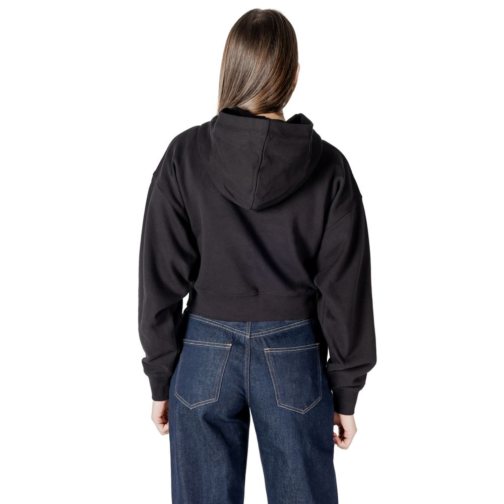 Woman in a black cotton sweater and blue jeans showcasing Calvin Klein Jeans style