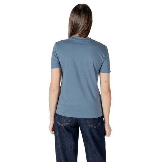 Woman in Calvin Klein Jeans blue cotton rigenerato top and dark jeans