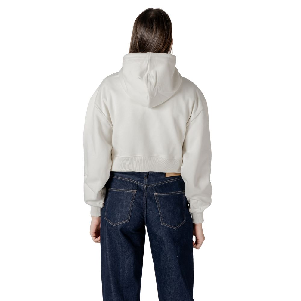 Woman in cropped hoodie and dark jeans showcasing Calvin Klein Jeans Cream Cotton Sweater