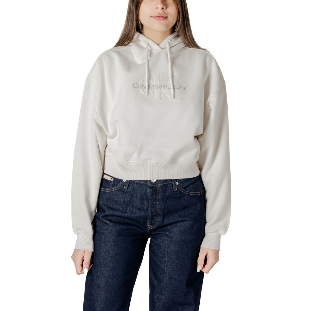 Woman wearing Calvin Klein Jeans cream cotton sweater with dark jeans for a stylish look