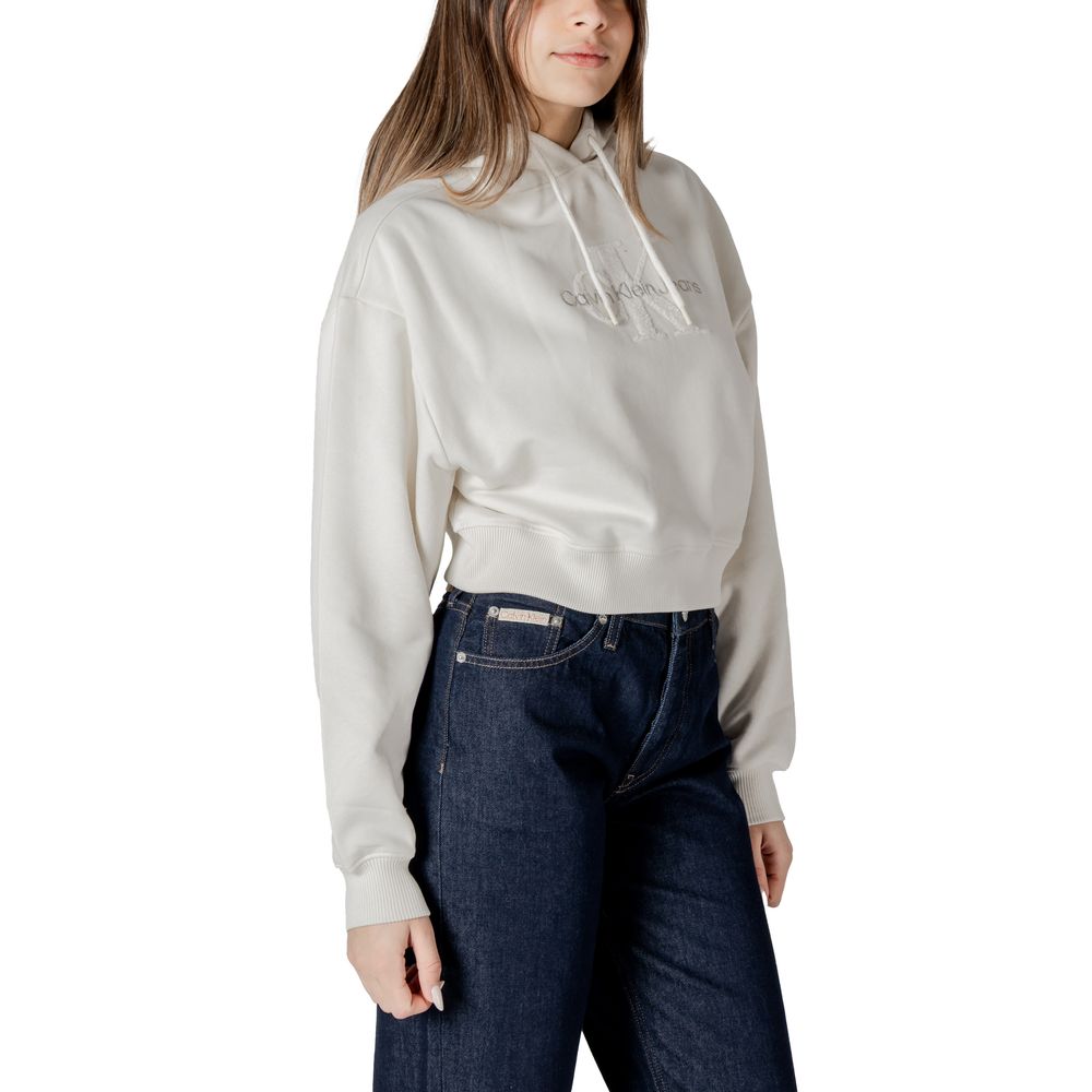 Woman in light gray hoodie and dark blue jeans showcasing Calvin Klein Jeans cream cotton sweater