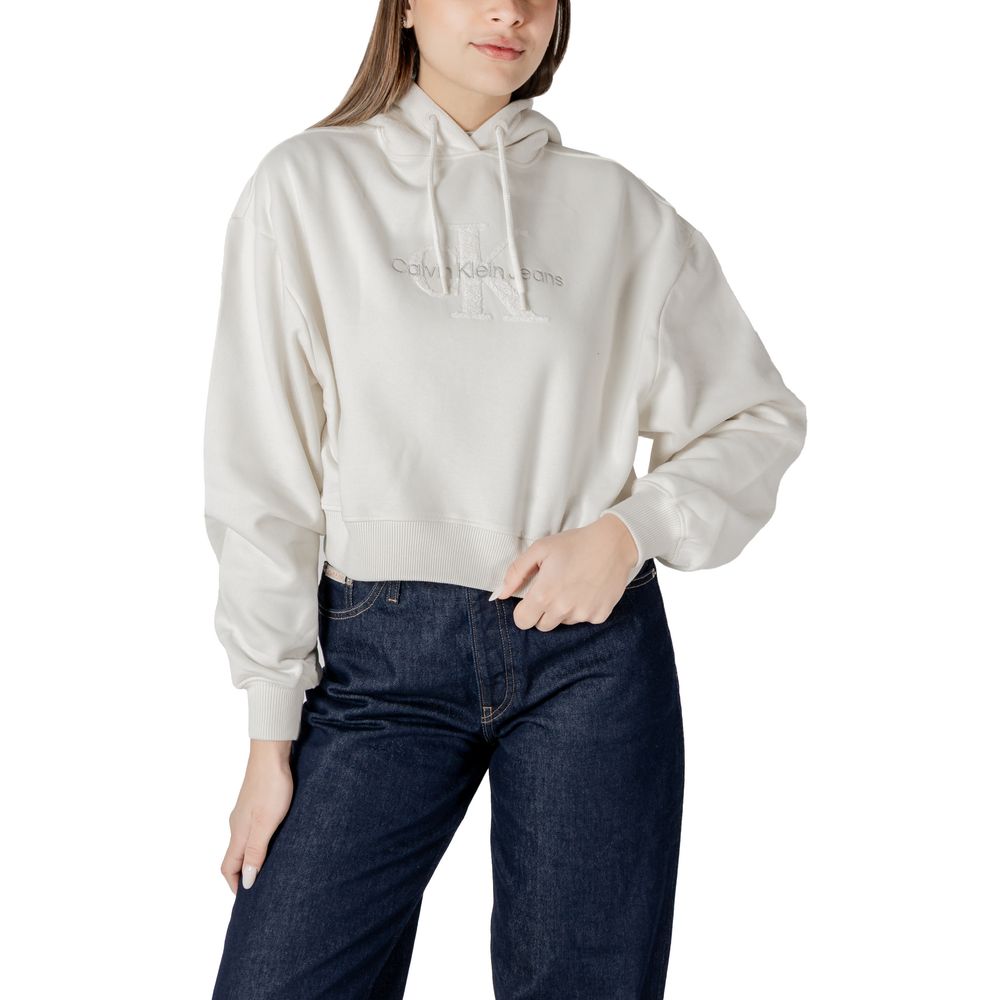 Woman wearing Calvin Klein Jeans cream cotton sweater with cropped hoodie and jeans