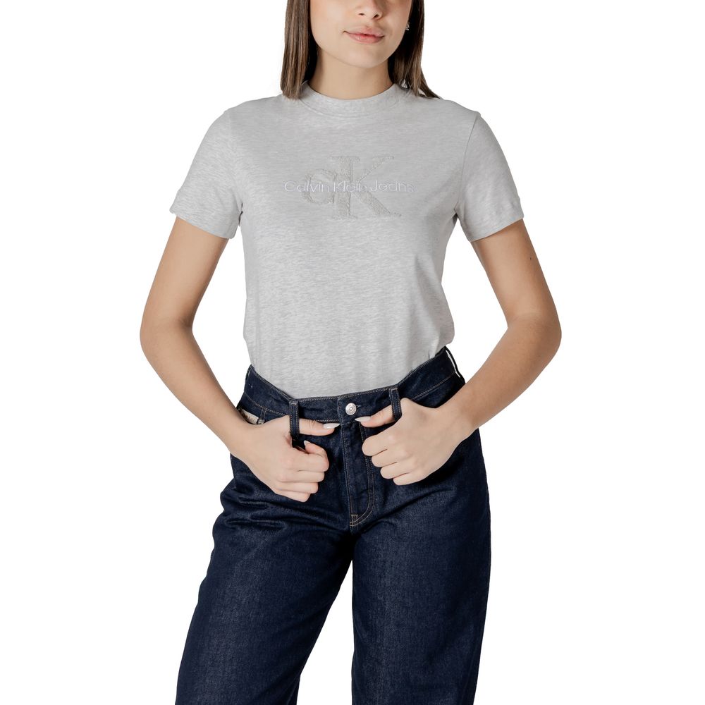 Woman in gray cotton top and dark blue jeans from Calvin Klein Jeans collection