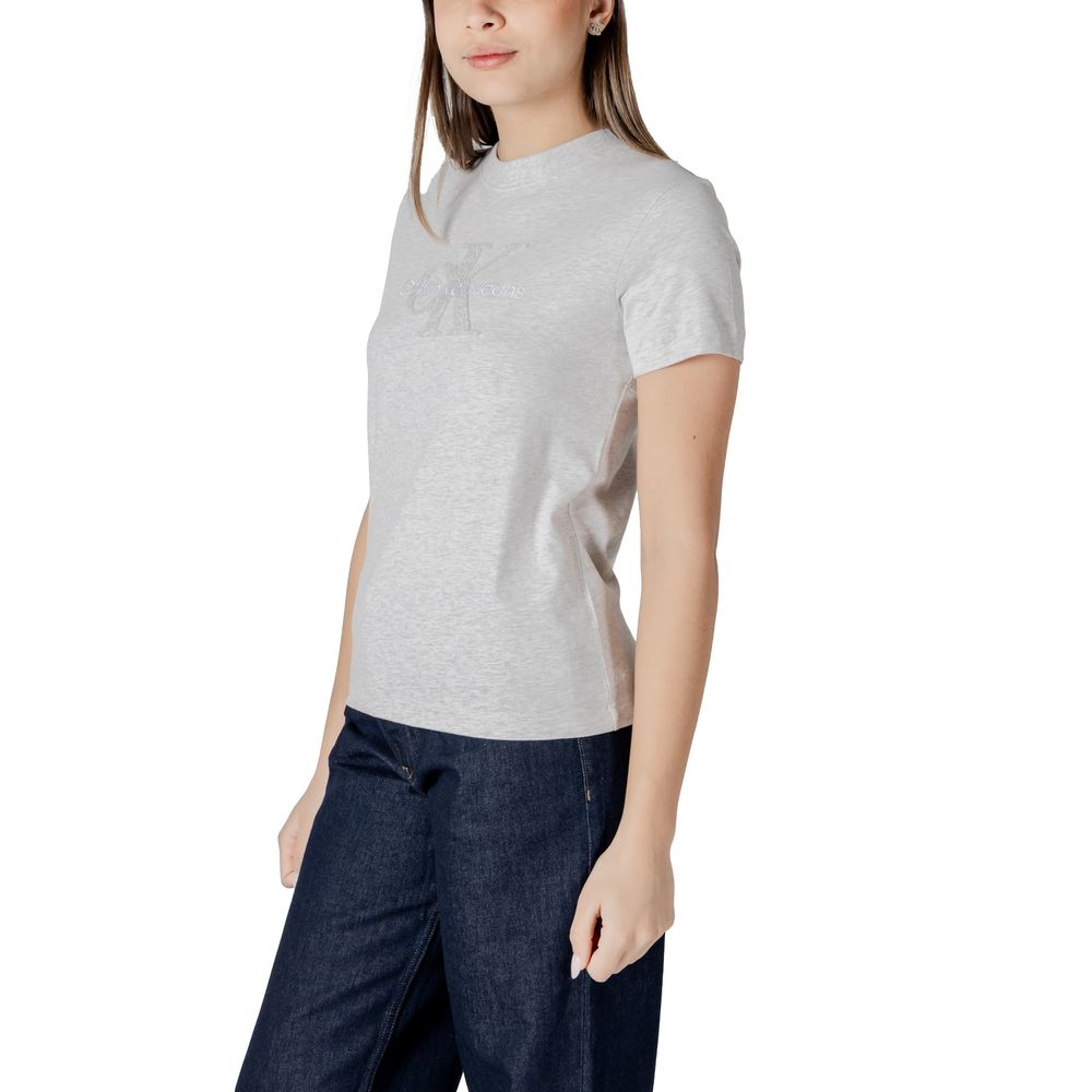 Woman in gray cotton top and dark blue pants from Calvin Klein Jeans collection